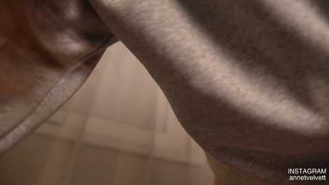 Video of a close-up of a hairy male leg in a light-colored shirt, with a blurred background of beige tiles.