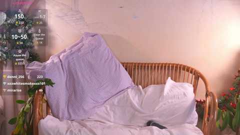 Video of a messy, unmade bed with a purple blanket covering a pillow, set against a beige wall with a digital overlay displaying health metrics and social media icons.